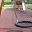 Single Swing (BNS 90cm) altalena a rete rotonda in un parco giochi con pavimentazione di sicurezza e struttura per arrampicata in