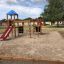 Parco giochi per bambini con torre per arrampicarsi e scivolo.