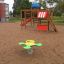 Parco giochi per bambini con struttura Climbing Booth e cavalluccio a molla su terreno sabbioso.