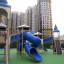 Citadel castle with slide in un moderno parco giochi vicino a edifici residenziali alti