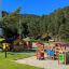 Alpha playhouse with slide in un'area giochi soleggiata vicino al bosco