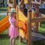 Bambino che gioca su Alpha playhouse with slide