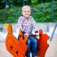 Bambino che gioca su Bulldozer rocking nel parco giochi.