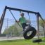 Ragazzo che si dondola su Double Tyre double swing nel parco giochi.