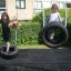 Bambini che giocano su un Double Tyre double swing in un giardino.