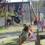 Bambini che giocano su Double Tyre double swing in un parco giochi.