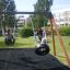Bambini che giocano su un Double Tyre double swing in un parco giochi.