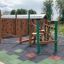 Spillikins wooden playhouse in un parco giochi con strutture da arrampicata e pavimentazione antitrauma in gomma.
