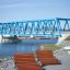 Montpellier Deck Chair in riva al fiume con un ponte blu sullo sfondo