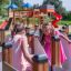 Due bambine che giocano nella struttura labirinto del parco giochi Ariadne con uno scivolo sullo sfondo.