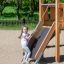 Bambino che gioca su Hexagon Modern Nature single slide in un parco giochi.