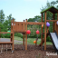 Triangle Modern Nature wooden playhouse with slide in un parco decorato con palloncini colorati