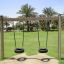 Wooden Tire double swing in un parco con palme sullo sfondo.
