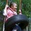 Bambino che si diverte su Wooden Tire double swing in un parco