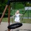 Bambino che gioca su un Triple swing in un parco.