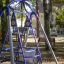 Wheelchair Swing in un parco circondato da alberi e panchine