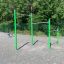 Barre di trazione in metallo per esercizi all'aperto in un parco giochi con pali verdi e tre diverse altezze.