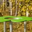Clover Play Table in un contesto di parco con parte superiore verde e gambe in metallo.