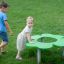 Bambini che giocano intorno a Clover Play Table in un parco.