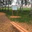 Panca in legno con gambe in acciaio in un parco.