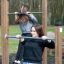Donne che si allenano sulle sbarre per trazioni in una palestra all'aperto.