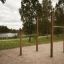 Sbarre per trazioni outdoor per allenamento in un'area parco con alberi e un lago sullo sfondo.