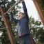 Uomo che usa attrezzatura fitness outdoor con sbarre per trazioni.