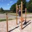 Uomo che usa attrezzatura per esercizi outdoor con sbarre per trazioni.