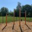 Sbarre per trazioni outdoor in un'area giochi con superficie in cippato di legno.