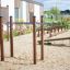 Attrezzatura fitness per esterni Bars I in un'area giochi sabbiosa.