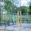 Stazione fitness all'aperto Bars II con panchine circostanti in un parco.