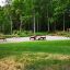 Attrezzatura fitness all'aperto Bars II allestita in un parco verde.