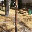 Palo da arrampicata in legno con maniglie metalliche in un parco giochi.
