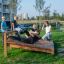 Bambini che si allenano su una panca per sit-up in un parco.