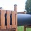 Tunnel per area giochi in legno Romping Cottage in un parco.