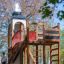 Alcazar playground castle con struttura in legno e scivolo in un contesto di parco
