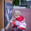 Un bambino piccolo che disegna su un Blackboard in un parco giochi.