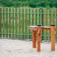 Attrezzatura da parco giochi Xylophone in un'area giochi sabbiosa con una recinzione in legno sullo sfondo.