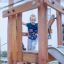 Bambino che gioca su Etna struttura da gioco in legno con uno scivolo.