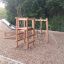 Caucasus wooden playhouse con scivolo e struttura da arrampicata in un parco giochi