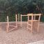Caucasus wooden playhouse su un parco giochi in ghiaia.