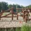 Casetta da gioco in legno Kalahari in un parco giochi sabbioso.