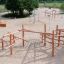 Casetta da gioco in legno Sonora in un ampio parco giochi sabbioso.