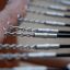 Primo piano dei dettagli costruttivi della casetta da gioco in legno Sonora che mostrano catene metalliche e connettori.