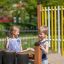 Bambini che giocano con tamburi musicali da esterno in un parco giochi.