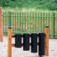 Strumento a percussione per parco giochi Drums con cilindri neri e struttura in legno.