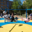 Attrezzatura da gioco Six Arm Swing Silver con bambini che giocano sulle altalene in un parco soleggiato.