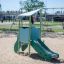Mars playhouse with slide in un parco giochi sabbioso.