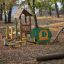Attrezzature da gioco all'aperto per bambini in un parco circondato da alberi - casa di Alice.