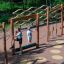 Bambini che giocano su attrezzature da parco giochi all'aperto in legno Trim Trail Nature II nel parco